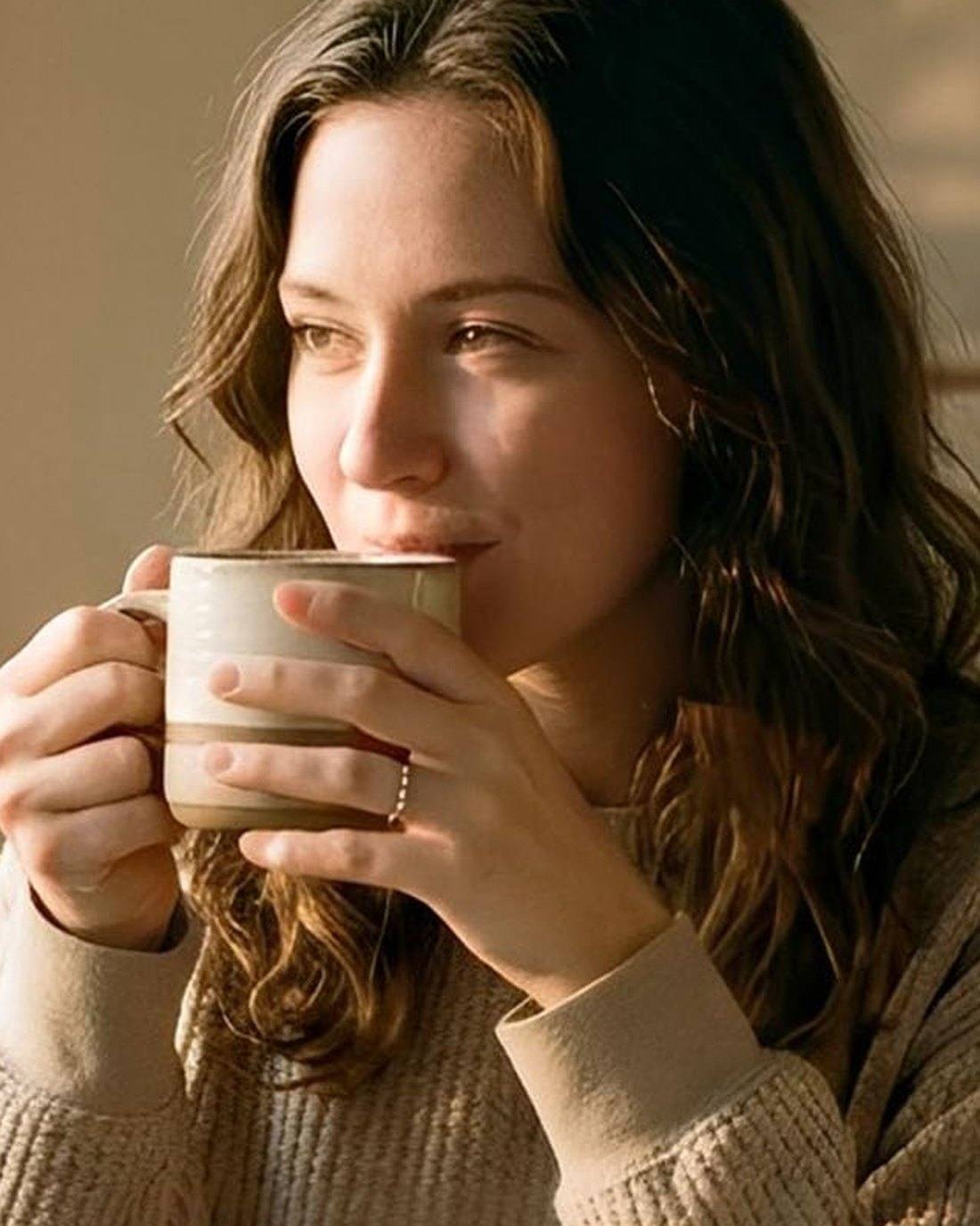 Woman warming her hands around a mug of Goorello cocoa